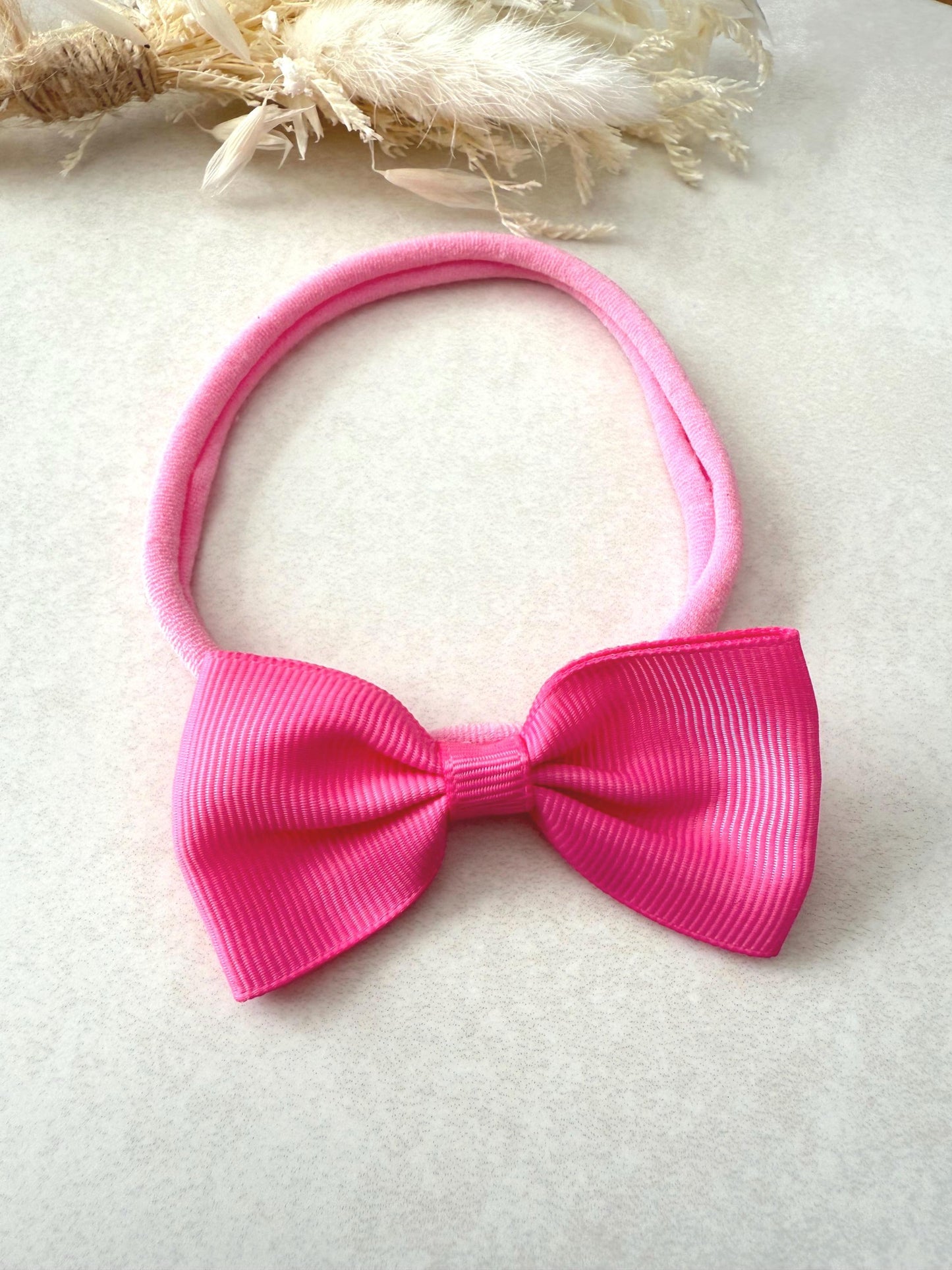 Pink Grosgrain ribbon bow headband on a nylon dainty headband for baby girl toddler and adult